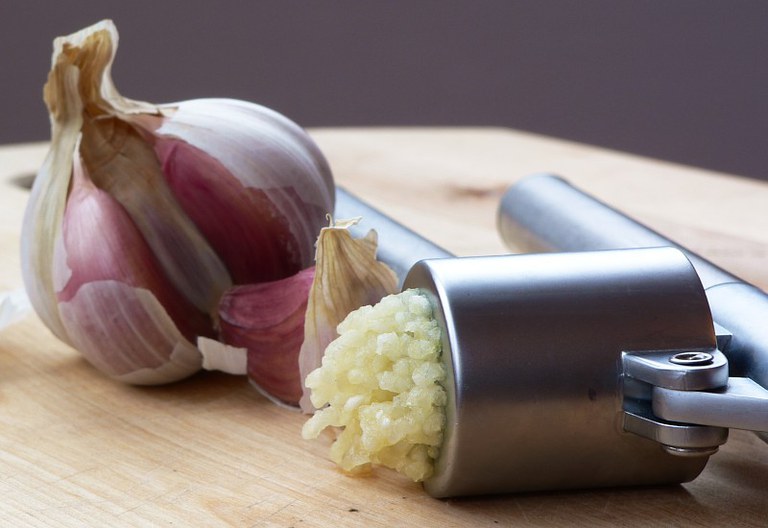 Garlic with a garlic press. Photo by Lee Kindness
