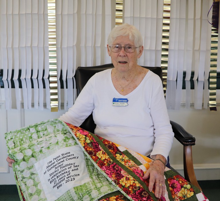 Shirley Halliday with the embroidered quilt she received from the Penn State Master Gardeners of Cumberland County