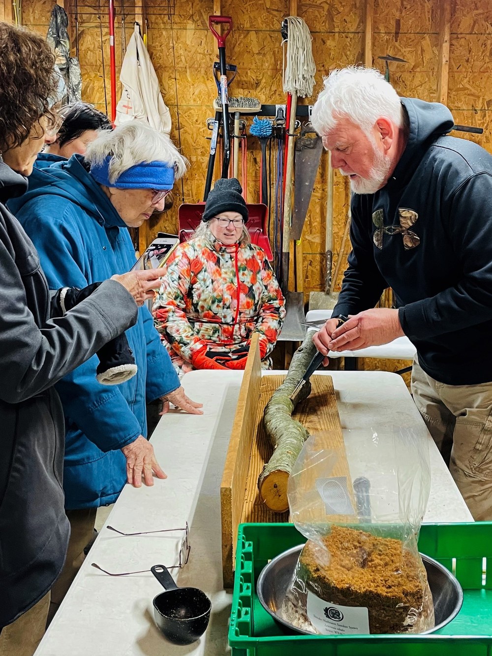 Harry Leslie shows Master Gardeners how to inoculate logs with mushroom spawn. (Photo Credit to Mary Sturdevant)